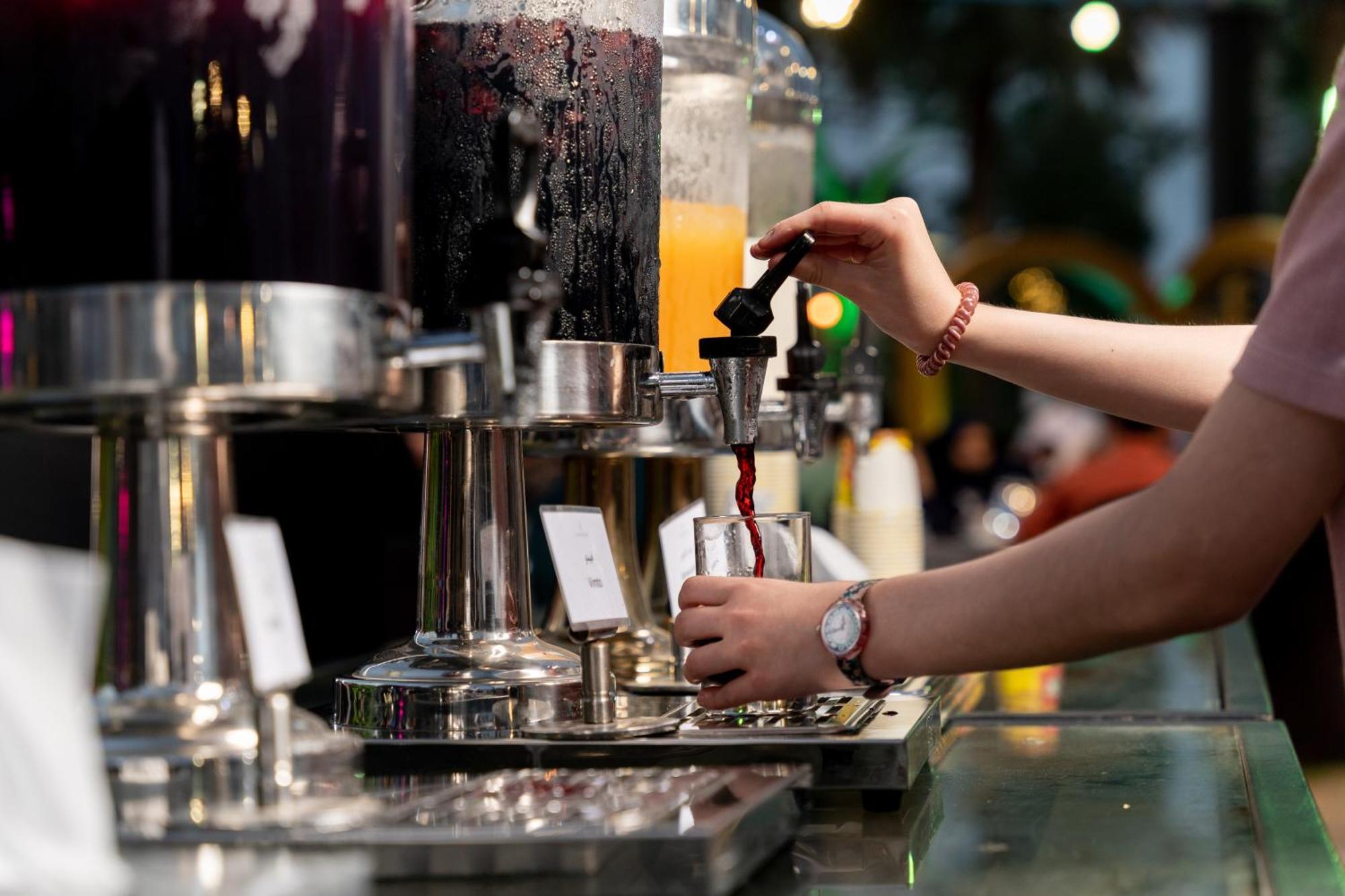 쉐라톤 담맘 호텔 앤 컨벤션 센터 외부 사진 A bartender using a tap to serve a drink